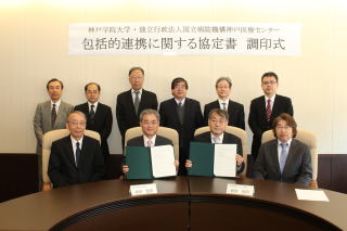 写真は、調印式を終えた岡田学長（前列中央左）と島田院長（前列中央右）ら